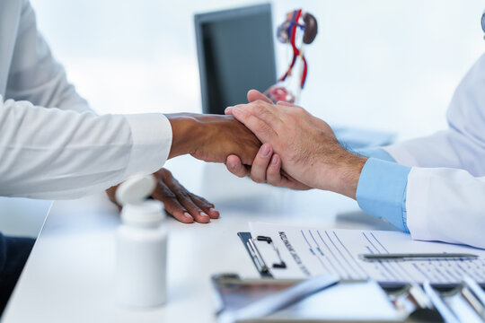 close-up doctor reassuring handshake with male patient, during medical consultation about men health issues such as prostate cancer, cystitis, or urinary tract infection.