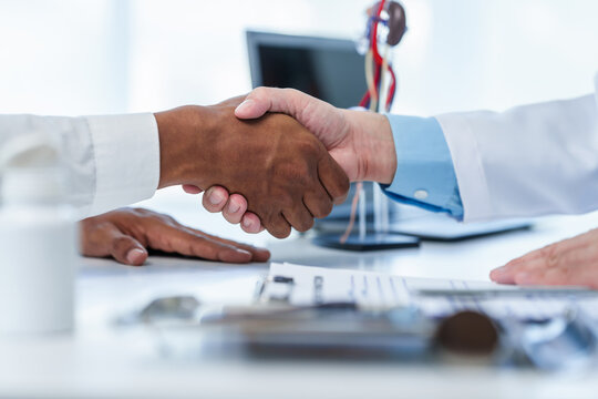 close-up handshake between two individuals, doctor and other casual shirt. doctor-patient relationship, agreement on treatment plan,  conclusion of medical consultation.