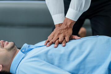 Close up man lying down while another individual, likely a medical professional, is performing a CPR chest compression, potentially in response to heart attack. - obrazy, fototapety, plakaty