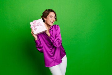 Photo of smiling beautiful young brown bob hair lady hold pink surprise package at birthday holiday isolated on green color background