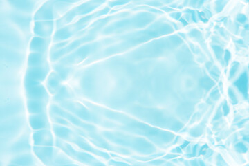Bluewater waves on the surface ripples blurred. Defocus blurred transparent blue colored clear calm water surface texture with splash and bubbles. Water waves with shining pattern texture background.