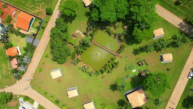 Descending over a children's park in a leisure area with a  water  fountain pouring water into a lake located in  a luxury private condominium at Brasil.Drone shot