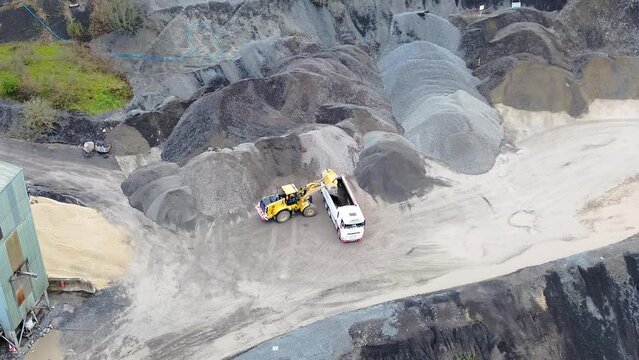 Tipper loading lorry with gravel in Quarry