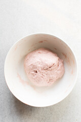 Beet Focaccia dough in a white bowl, process of making pink focaccia, beet dough rising in a white mixing bowl	