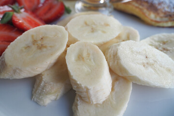 Fototapeta na wymiar close up of slice of banana glass , strawberry and honey on a plate