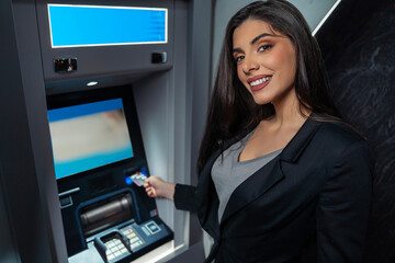 Amazing Caucasian , European woman next to ATM at night, looking at camera