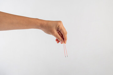 Pink hair tweezers in hand isolated on white background