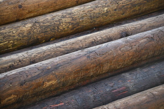 Pile of wooden electrical poles ready for installation.