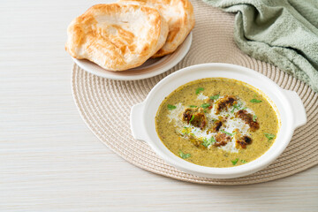 Afghani chicken in green masala curry or Hariyali tikka chicken hara masala with roti or naan bread