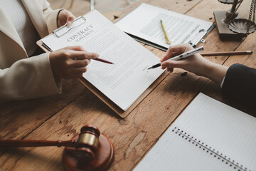 Business people negotiating a contract, discussing contract while working together in sunny modern...