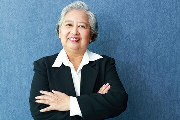 Portrait of an elderly Asian businesswoman wearing a suit. She smiles happily. Business concept....