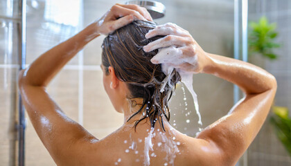 Naklejka premium Woman washing his hair in the shower, close-up, rear view
