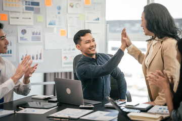 diverse group of Asian professionals, including middle-aged and mature individuals, gathered around...