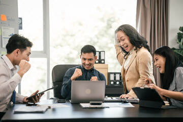 diverse group of Asian professionals, including middle-aged and mature individuals, gathered around a table in a business setting, discussing documents with focused attention.