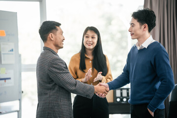 Asian real estate agent team engaged in a discussion, with two men and a woman focusing on a house...