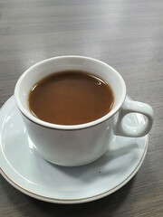 Coffee in a cup on wooden table and blur background with bokeh image