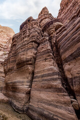 A shallow  stream flows between rocks painted with beautiful natural patterns at beginning of Wadi Numeira waking trail in Jordan