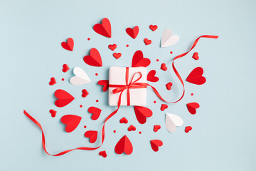 Valentine or Mother day festive composition with gift or present box and red hearts on pastel blue...