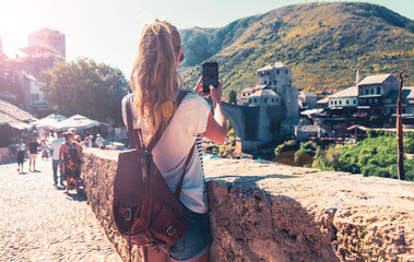 Female tourist photographing old bridge in Mostar city- Bosnia and herzegovina