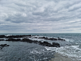 The rough sea of ​​Jeju is covered in dark clouds.