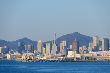 神戸の街並み。高層ビルが山と海に挟まれた景色。