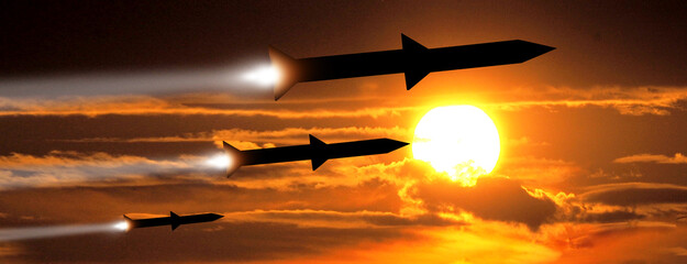 Fired missiles fly to the target. Missiles at the sky at sunset. Missile defense. Rockets attack...