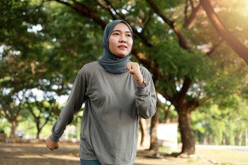 Portrait of asian muslim girl enjoy jogging in the morning in the garden field