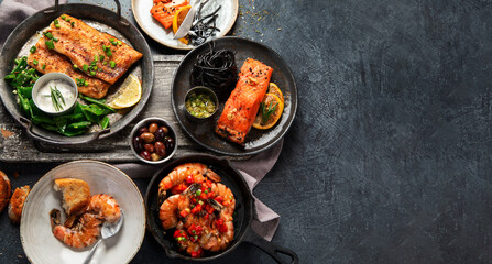 Grilled salmon fish fillet with lemon and strimps. Sea food dishes assorty. Healthy concept