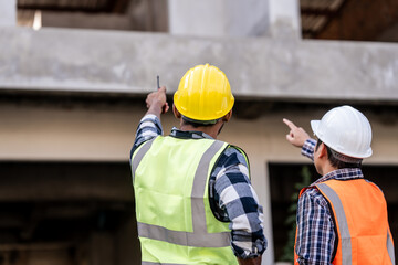 Asian people, two man, holding blueprints Structural engineers examine structural plans for office...