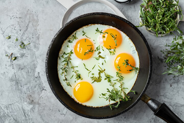 egg breakfast. Fried eggs in a frying pan sprinkled with herbs. fresh breakfast concept