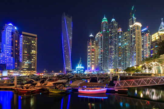 Dubai, UAE - March 31, 2014: Skyscrapers of Dubai Marina at night, UAE. Dubai Marina is a district in Dubai with artificial canal city who accommodates more than 120,000 people at Persian Gulf.