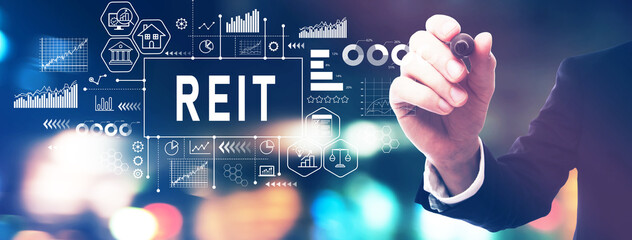 REIT - Real Estate Investment Trust theme with a businessman in a blurred city lights at night