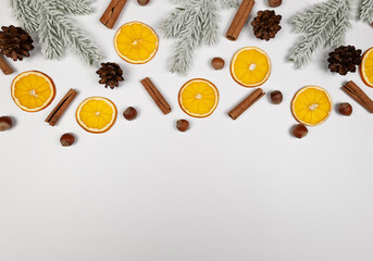 Christmas composition, dried orange slices, fir tree branches, cinnamon sticks, pine cones, hazelnuts on white background. Christmas, New Year, winter concept. Top view, flat lay, copy space.