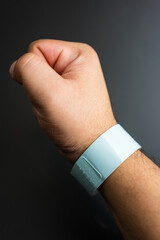Fototapeta premium Empty concert bracelet on hand, mockup on a black background. Event ticket concept