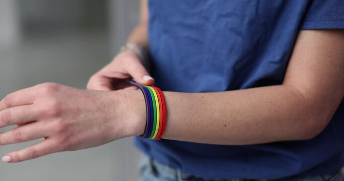 Woman hand putting on bracelet with lgbt emblem closeup 4k movie slow motion