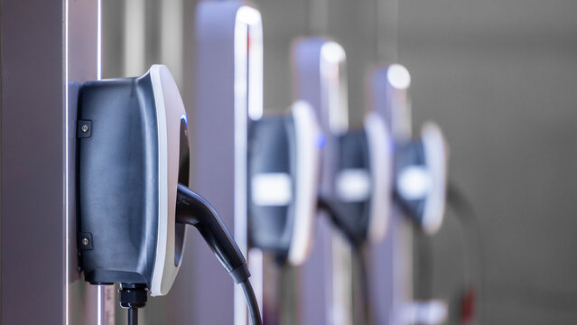 EV charging and electric car, Electric car charging station for charge EV battery, Plug for vehicle with electric engine, EV charger clean energy, Charging point at car parking lot.