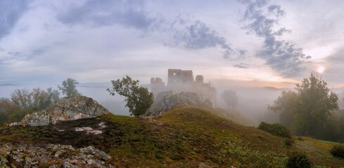 Autumn colorful foggy morning at sunrise. Typical autumn atmosphere with an old castle ruin in the...