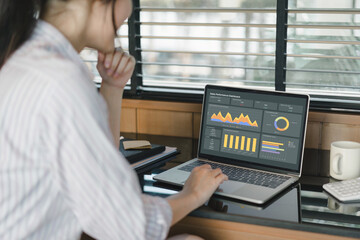 Fototapeta na wymiar Businesswoman or accountant team analyzing data charts, graphs, and dashboard on laptop screen to increase sales and revenue. Business data analytics concept.