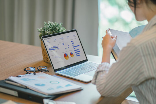 Businesswoman accountant using a graphs and charts to analyze market data, balance sheets,accounts,and net profits in order to plan new sales strategies and increase production capacity.