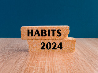HABITS 2024 symbol. Concept words HABITS 2024 on brick blocks. Beautiful wooden table, blue...