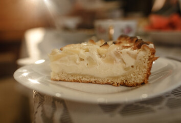 A piece of apple pie with curd cream on a plate