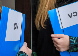 Kobieta szuka pracy, trzyma swoje cv podczas rozmowy kwalifikacyjnej - obrazy, fototapety, plakaty