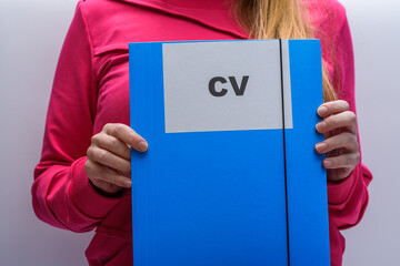 Młoda dziewczyna  podczas rekrutacji trzyma w dłoniach swoje CV curriculum vitae - obrazy, fototapety, plakaty