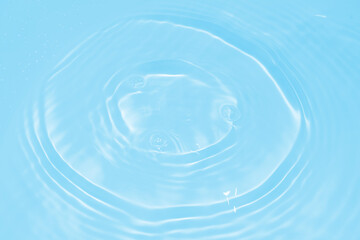 Fototapeta na wymiar The surface of the water dripped and rippled in the basin. The transparent blue water surface is slightly shaded with unclear details