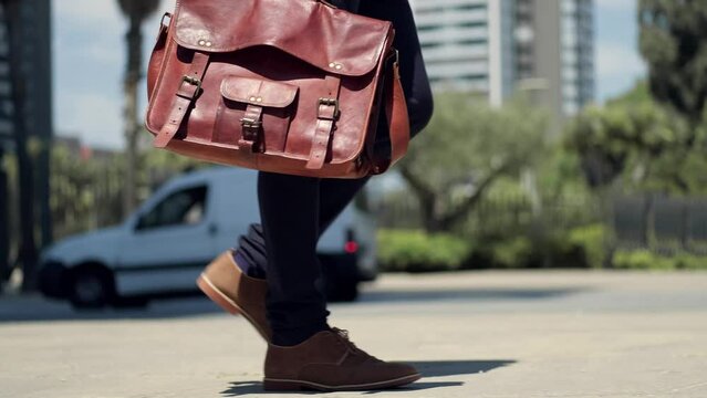 Businessman walking in urban street carrying briefcase