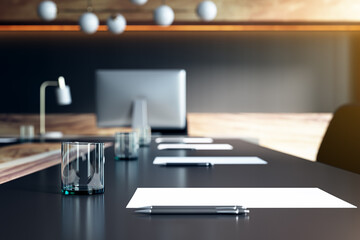 Close up of table with objects in modern conference room. Blurry interior background. Workplace...