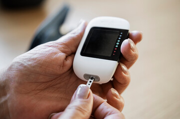 Senior woman doing blood sugar test with glucometer