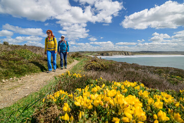 France, Brittany, Man and woman hiking along Sentier Cotier GR34 route in summer