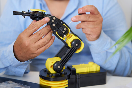 Engineer working on robotic arm in office