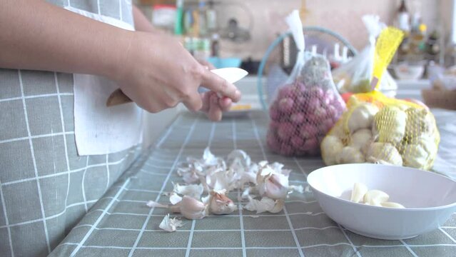 Woman peeling the garlics preparing for cooking the food